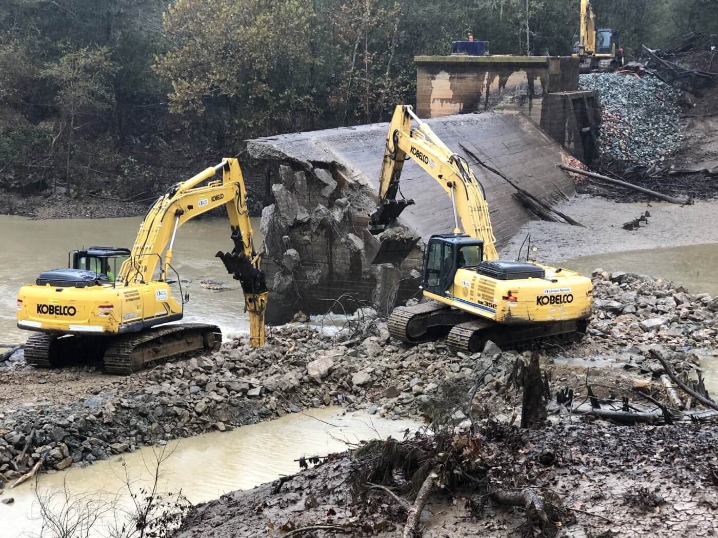 Two excavators breaking up the concrete Hoosier Dam on the Little River in North Carolina